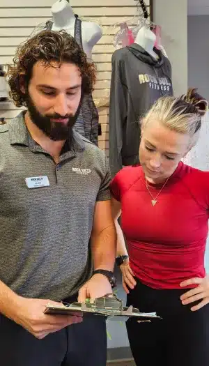 Personal trainer speaking with client about High Intensity SAFE Strength Training at Rock Solid Fitness